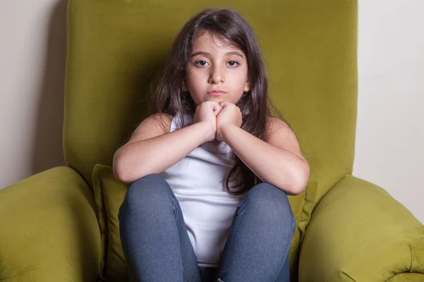 Infeliz pequeña hermosa chica de Oriente Medio con camiseta blanca y pelos negros mirando a la cámara . —  Fotos de Stock