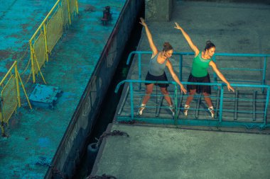 İki genç güzel ikiz kardeş şehir Balesi kostüm bale. kentsel eşitleme dans. Sanayi Caddesi dans. özel efekt ile. poz senkronize. Pointe bale ayakkabıları ve elbise.