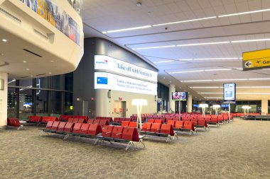 New York, ABD - 29 Mart 2024: Yenilenmiş LaGuardia havaalanı terminalinde sayısız kırmızı koltuklu B Terminali açık dinlenme alanı