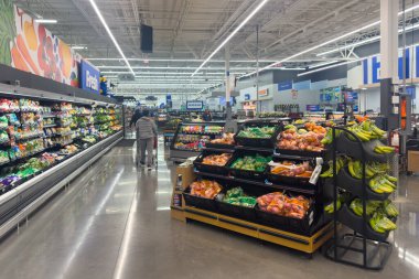 Frisco, Teksas, ABD - 12 Eylül 2025: Parlak ışıklı Walmart ürünleri reyonunda büyük soğanlar, salatalıklar, domatesler ve biberlerin yer aldığı taze sebze bölümünün yakın çekimi