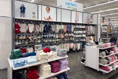 Frisco, Teksas, ABD - 12 Eylül 2025: Masaların üzerinde düzgün katlanmış giysiler, renkli vitrinler ve geniş bir perakende alanında çocuk giysileri rafları olan çocuk giyim reyonu