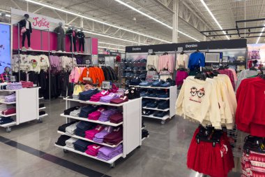 Frisco, Teksas, ABD - 12 Eylül 2025: Masaların üzerinde düzgün katlanmış giysiler, renkli vitrinler ve geniş bir perakende alanında çocuk giysileri rafları olan çocuk giyim reyonu