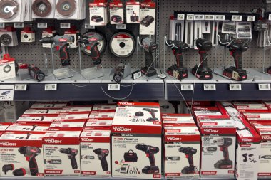 Frisco, Teksas, ABD - 12 Eylül 2025: Güvenli hiper sert kablosuz darbe sürücüleri, matkaplar, pil paketleri, tekerlekleri ve aksesuarları olan tahta raf