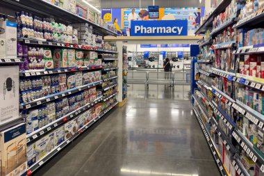 Frisco, Teksas, ABD - 12 Eylül 2025: Vitaminler, beslenme içecekleri, ilaveler ve eczane tezgahına giden sağlık ürünleri raflarıyla dolu iyi stoklanmış Walmart eczane koridoru