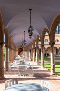 Tucson, Arizona, ABD - 17 Ağustos 2025: Pima İlçesi Tarih Adliyesi avlusu açık masa sandalyeli sütunlu yeşil çimenler ve fenerler