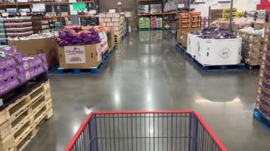 Prosper, Teksas, ABD - 12 Eylül 2025: Costco Store 'daki depo raflarında paketlenmiş gıda ürünleri ve istiflenmiş kutularla dolu market koridoru
