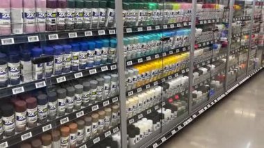 Frisco, Teksas, ABD - 12 Eylül 2025: Walmart hırdavat koridorundaki renklere göre düzenlenmiş çeşitli tonlarda Rust-Oleum 2X sprey boya kutularıyla dolu büyük cam kapı dolabı