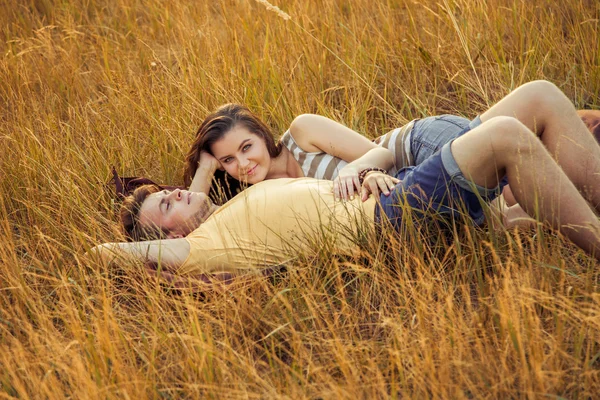 Casal amoroso deitado no campo floral no parque outonal. desfrutar, relaxar e r — Fotografia de Stock