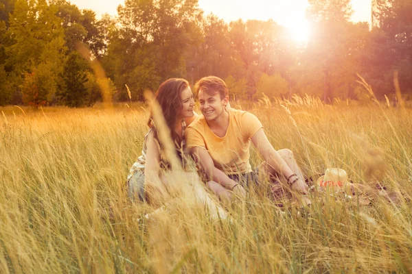 Casal amoroso deitado no campo floral no parque outonal, dia ensolarado quente, desfrutando de família, data romântica, felicidade e conceito de amor. felicidade e sorriso . — Fotografia de Stock