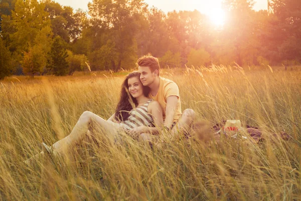 Szerető pár fekve virágos mező-őszi parkban. Élvezze, pihenjen és r — Stock Fotó