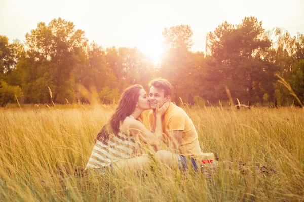 Loving couple lying down on floral field in autumnal park, warm sunny day, enjoying family, romantic date, happiness and love concept. hug and happiness. — Stock Fotó