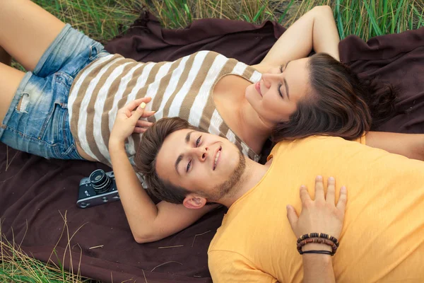 Pareja cariñosa acostada en el campo floral en el parque otoñal. disfrutar, relajarse y r —  Fotos de Stock