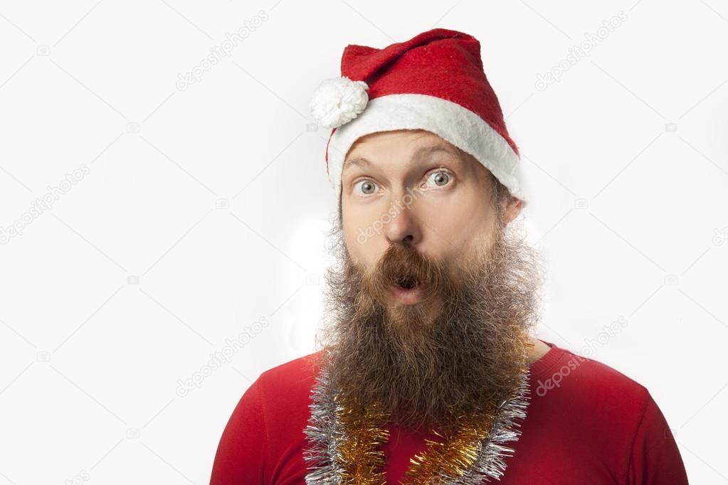 happy funny santa claus with real beard and red hat and shirt making crazy face and smiling, looking and camera.