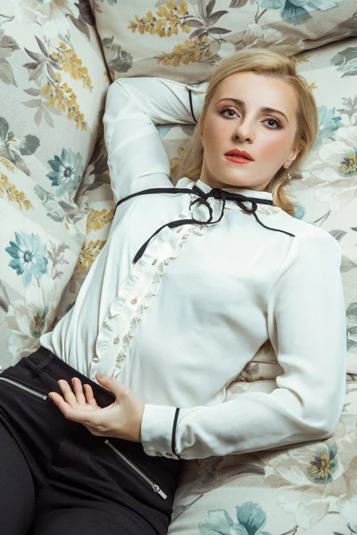 Beautiful young fashion caucasian blonde model posing on sofa. — Stock Photo, Image