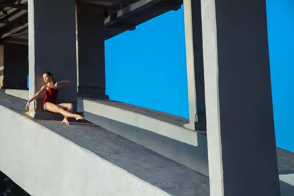 Young beautiful woman gymnast posing on bridge girder — Stockfoto