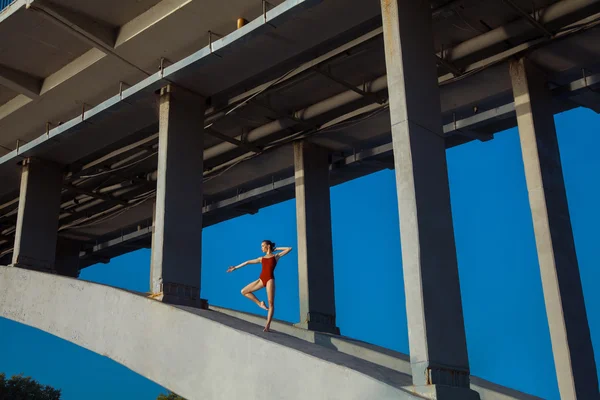 Joven hermosa mujer gimnasta posando en puente viga — Foto de Stock