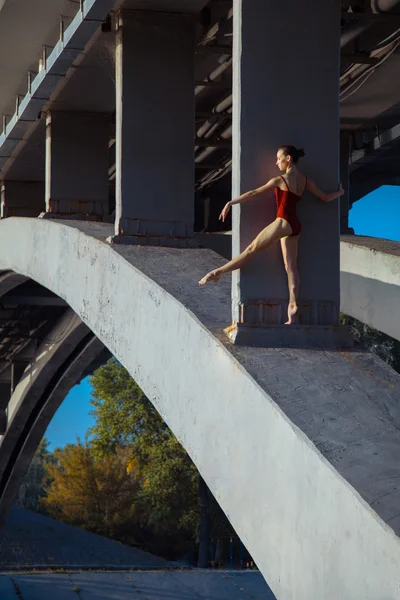 Young beautiful woman gymnast posing on bridge girder — Stockfoto