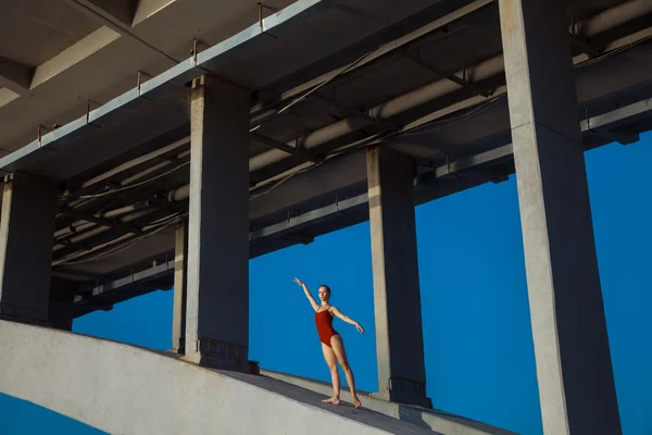 Молодая красивая гимнастка позирует на мостовой балке — стоковое фото