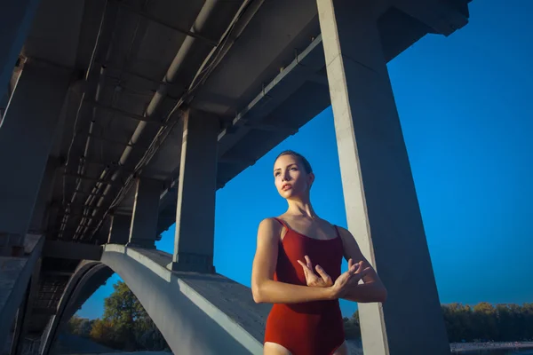 Young beautiful woman gymnast posing on bridge girder — Stok fotoğraf