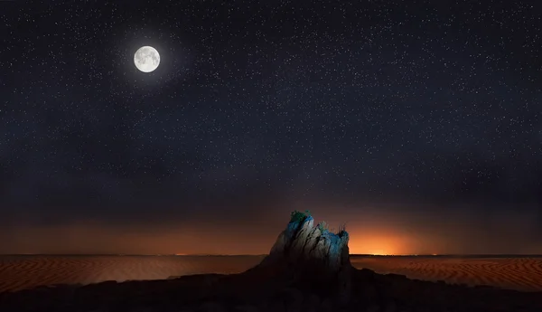Луна и звезды над камнем в пустыне — стоковое фото