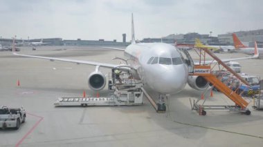 Auckland, Yeni Zelanda, 1 Ocak 2025. Park halindeki uçak, taksi pisti ve yer araçlarıyla aktif bir havaalanı manzarası.