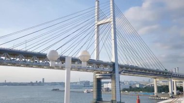 Yokohama Körfezi Köprüsü 'nün geniş bir görüntüsü yolcu gemisinin üst güvertesinden okyanus manzarasını ve yüksek köprü açıklıklarını yakalıyor. 