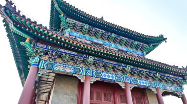 KaiFeng, Çin, 1 Ocak 2026, katmanlı çatıları, renkli parantezleri, kırmızı sütunları ve tarihi kale girişini koruyan törensel davulları olan geleneksel Çin kapı kulesi