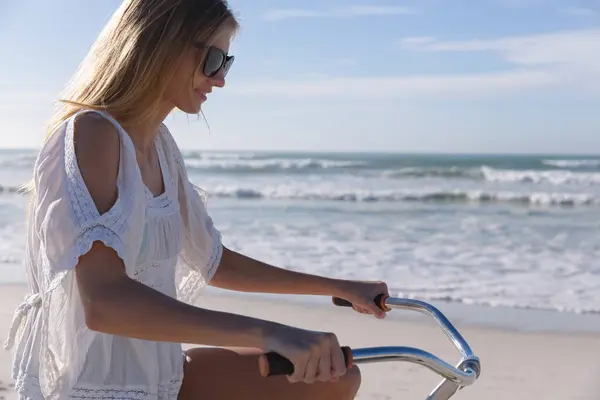 ビーチで自転車に乗っている白人女性 海による健康的な屋外レジャータイム — ストック写真