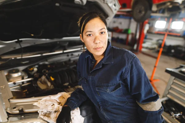 Mixed Race Female Car Mechanic Wearing Overalls Inspecting Car Looking — Stock Photo, Image