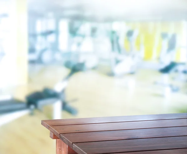Tischplatte und verschwommenes Fitnessstudio im Hintergrund — Stockfoto