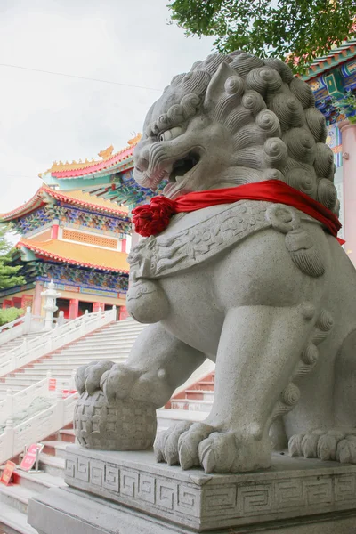 Leão pisando mundo como estátua de pedra frente templo chinês — Fotografia de Stock