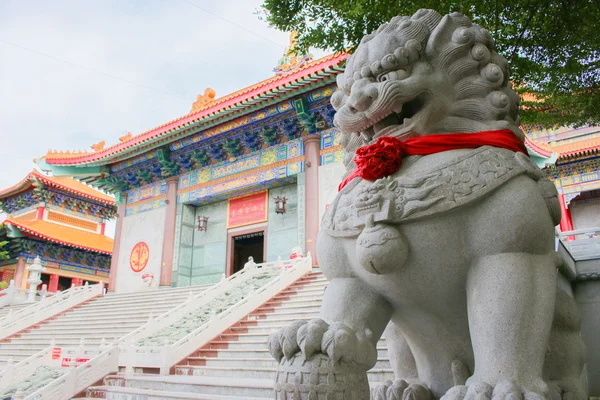 Lion stepping world as stone statue on foreground — Stock Photo, Image