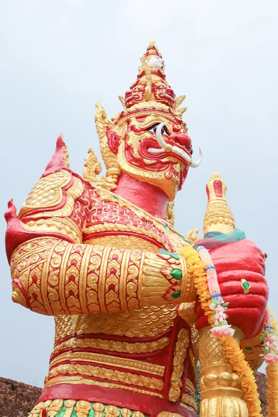 Statue géante rouge debout sur fond de ciel blanc — Photo