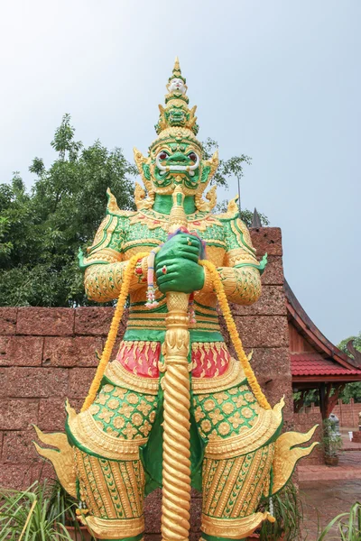 Groene reus standbeeld staande voorkant van tempel muur — Stockfoto