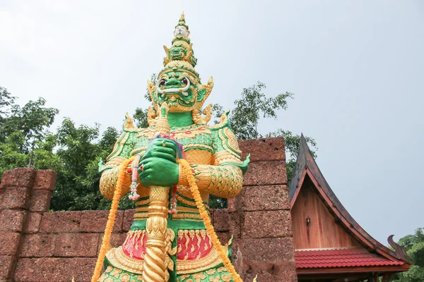 Estatua gigante verde de pie frente a la pared y el fondo del templo — Foto de Stock