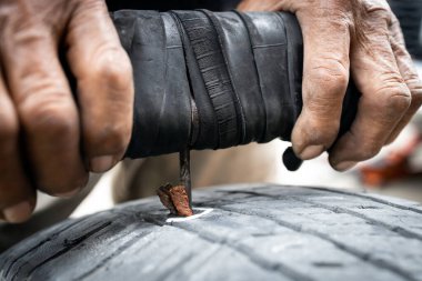 Lastik yama, lastik lastiği tamir eden yaşlı bir adamın elleri çivili lastik yüzeyi tamir ettirme lastik lastik lastik lastik lastik lastiği, lastik iğne saplama ve ponksiyona yapıştırma.