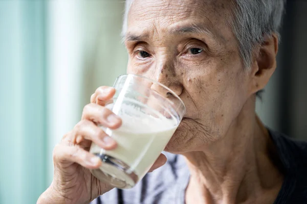 Азиатская Старшая Женщина Пьет Теплое Свежее Молоко Стекла Утром Дома — стоковое фото