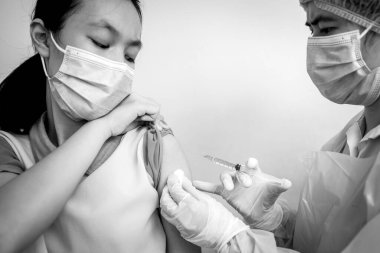 Doktor Coronavirus aşısını çocuk kızın omzuna enjekte ediyor, COVID-19 aşısı tehlikesi, tehlikeli ilaçların yan etkileri, aşı alerjisi, ilaç, aşı, tıbbi konsept