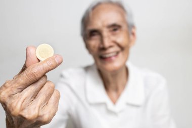 C vitamini tabletlerini kapat, yaşlıların elinde beslenme takviyesi, bağışıklık için ilaç, Asyalı yaşlı kadın içki, beslenme, sağlık konsepti için kalsiyum C vitamini tutmakta.