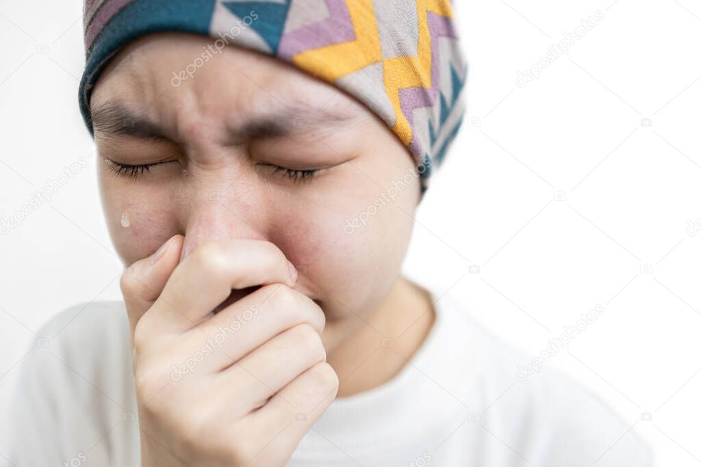 Asian child girl covers her head with a cloth,lady suffering from disease of Acute leukemia cancer,Depressed stressed female patient crying feeling tired and in pain from cancer chemotherapy treatment