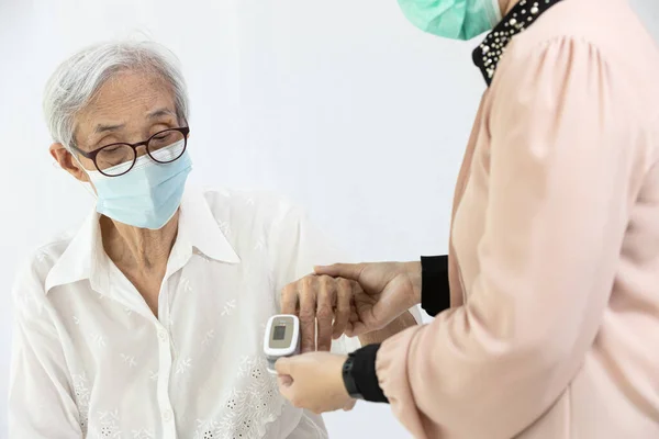 Kvinnlig Vårdgivare Med Fingertopp Pulsoximeter Fäst Fingret Äldre Hälsokontroll Mätning — Stockfoto