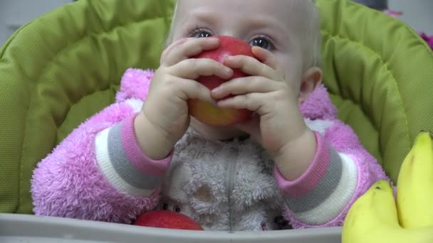 Lindo bebé comiendo una manzana, los primeros dientes. Primero intenta masticar. 4K UltraHD, UHD — Vídeo de stock