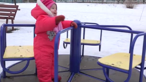 Zoete pasgeboren Baby spinnen op carrousel in een winterse dag. 4 k Ultrahd, Uhd — Stockvideo