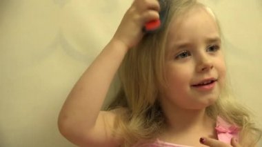 Kız yürümeye başlayan çocuk saç kendini bir saç tarak ve fırça ile Giydir. 4 k Ultrahd, Uhd