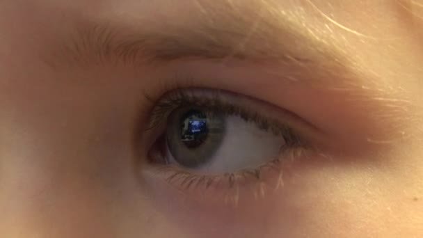 Closeup of Happy Baby Girl Eyes Looking TV, Reflections in Eyes (em inglês). 4K UltraHD, UHD — Vídeo de Stock