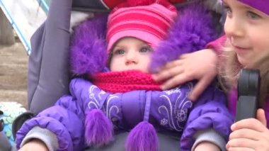 Küçük kız, yeni doğan kardeşi bebek arabası içinde bak. 4 k Ultrahd, Uhd