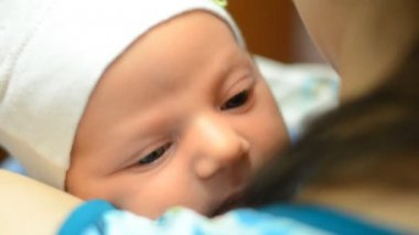 Yeni doğan bebek annesinin omzuna yalan