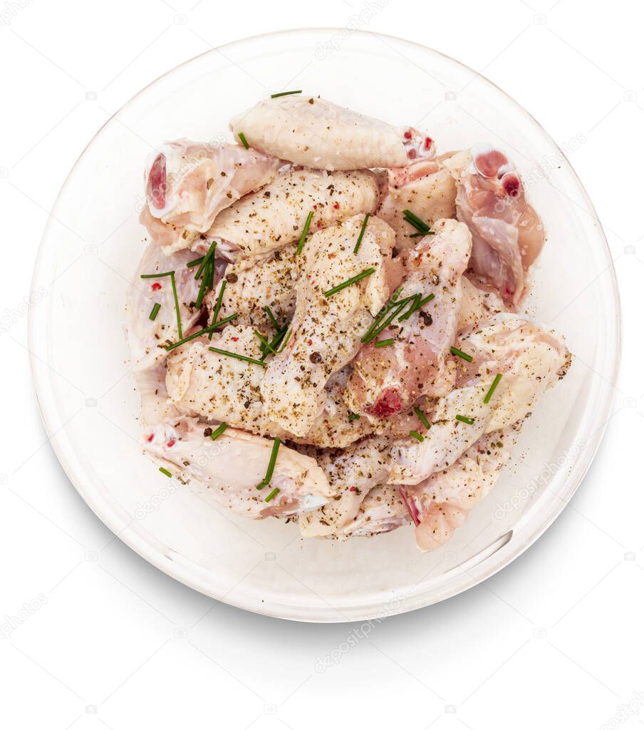 Raw chicken wings marinated with salt, pepper and chives in a bowl isolated on white background.