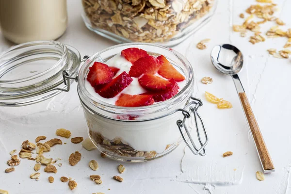 Delicious dessert of strawberries, yogurt and sugar-free cereals. On white background.