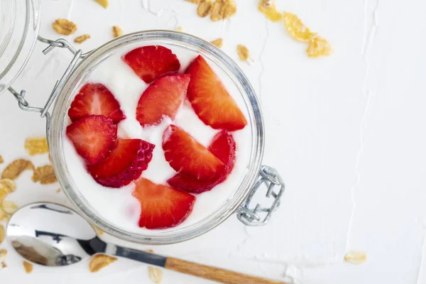 Delicious dessert of strawberries, yogurt and sugar-free cereals. On white background. With copy space